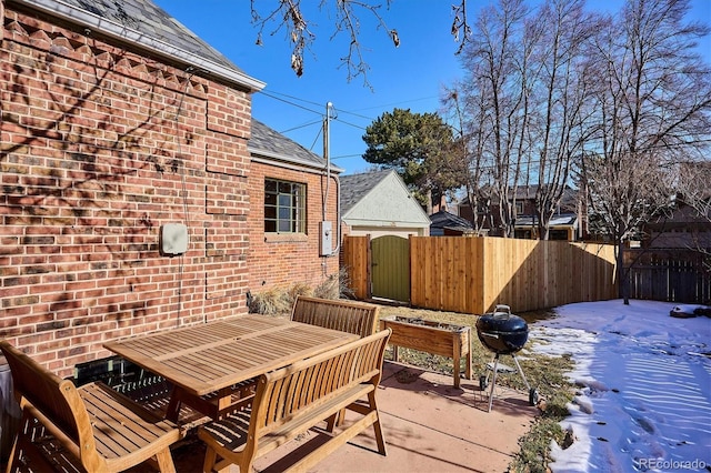 snow covered deck with a patio area