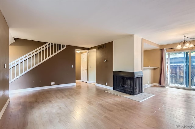 8759 E Roundtree Ave, Greenwood Village, CO 80111 - unfurnished living room featuring wood-type flooring, stairs, and a chandelier