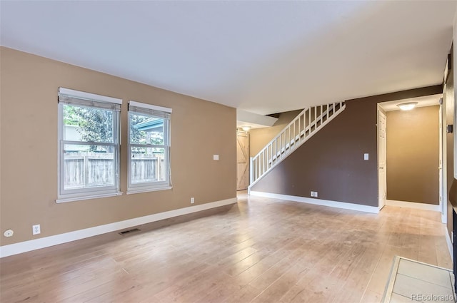 8759 E Roundtree Ave, Greenwood Village, CO 80111 - unfurnished living room with stairway and light wood-style floors