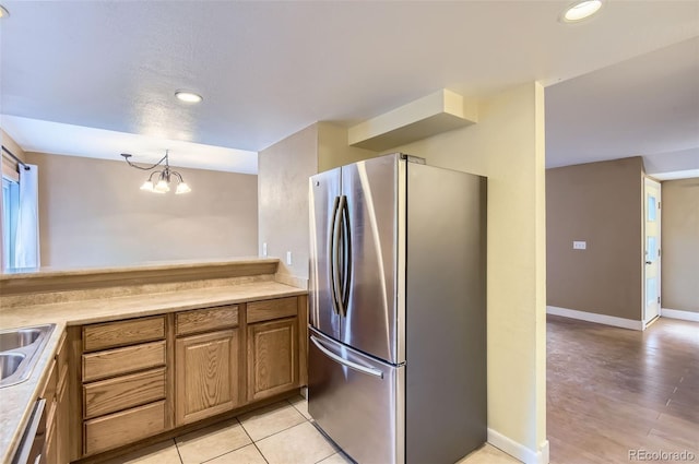 8759 E Roundtree Ave, Greenwood Village, CO 80111 - kitchen with appliances with stainless steel finishes, light countertops, recessed lighting, brown cabinets, and a chandelier