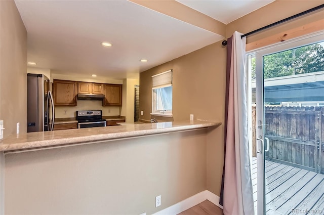 8759 E Roundtree Ave, Greenwood Village, CO 80111 - kitchen with appliances with stainless steel finishes, under cabinet range hood, light countertops, recessed lighting, and brown cabinetry