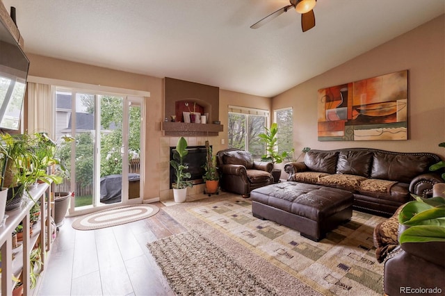 4759 Mt Princeton, Brighton, CO 80601 - living area with healthy amount of natural light, a tiled fireplace, a ceiling fan, lofted ceiling, and wood finished floors