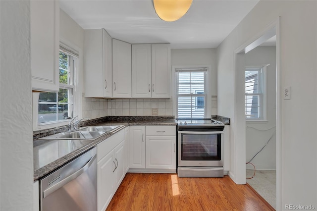 4480 S Pennsylvania St, Englewood, CO 80113 - kitchen with stainless steel appliances, white cabinets, tasteful backsplash, and light wood-type flooring