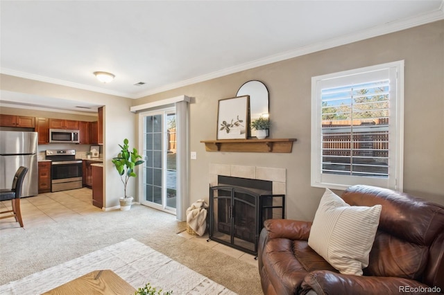 living room featuring a tiled fireplace, light carpet, and ornamental molding