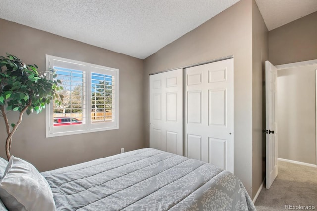 bedroom featuring a textured ceiling, a closet, carpet, and lofted ceiling