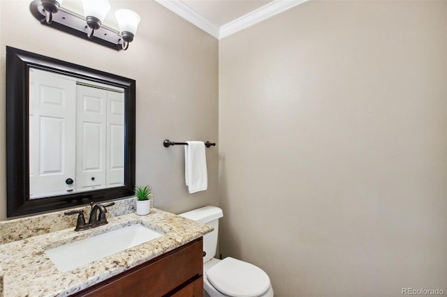 bathroom with toilet, vanity, and ornamental molding