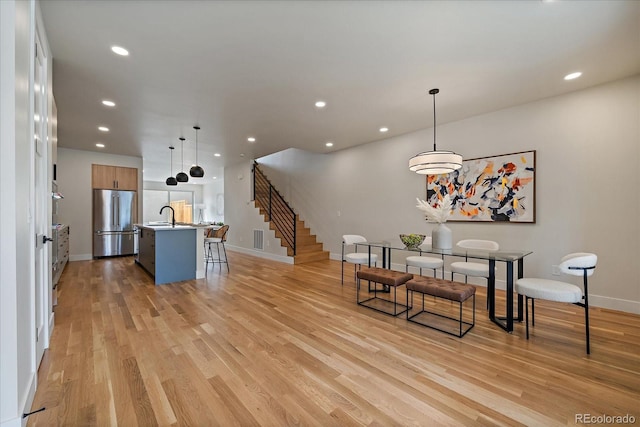 1423 Xavier St, Denver, CO 80204 - dining area featuring stairs, baseboards, light wood-style flooring, and recessed lighting