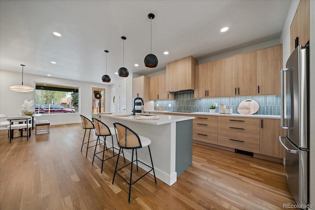 1423 Xavier St, Denver, CO 80204 - kitchen featuring freestanding refrigerator, modern cabinets, a breakfast bar area, tasteful backsplash, and recessed lighting