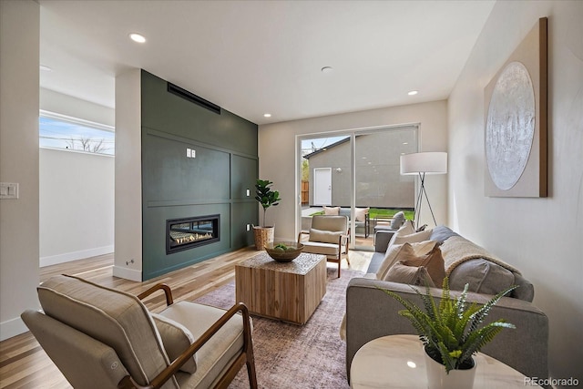 1423 Xavier St, Denver, CO 80204 - living area featuring plenty of natural light, a glass covered fireplace, light wood finished floors, baseboards, and recessed lighting