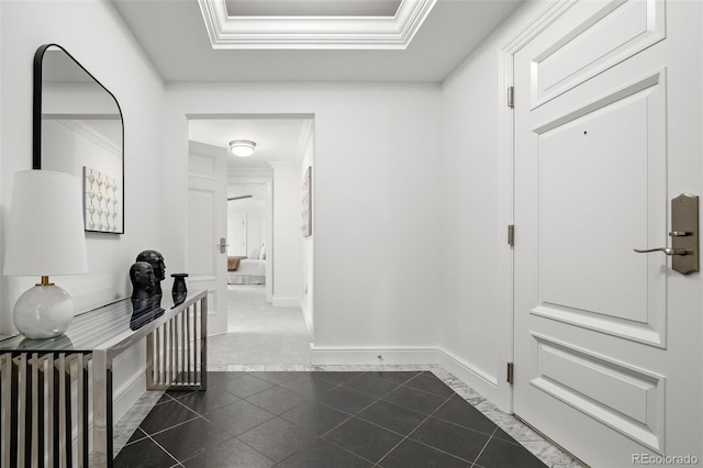 hall with crown molding, baseboards, radiator heating unit, a raised ceiling, and dark tile patterned flooring