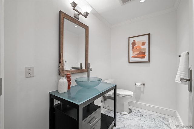 bathroom with marble finish floor, toilet, baseboards, and ornamental molding