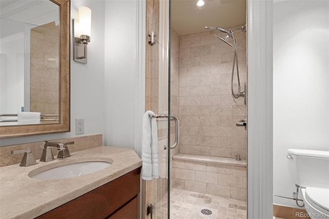 bathroom with a stall shower, toilet, and vanity