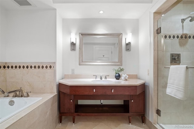 bathroom featuring tile patterned flooring, vanity, and shower with separate bathtub