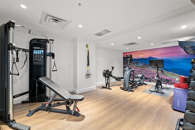 exercise room with light wood-type flooring and ornamental molding