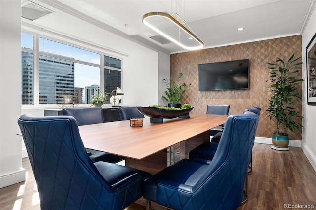 dining room featuring wallpapered walls, ornamental molding, baseboards, and an accent wall