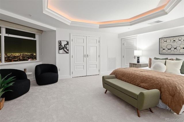 carpeted bedroom featuring two closets, crown molding, and a tray ceiling