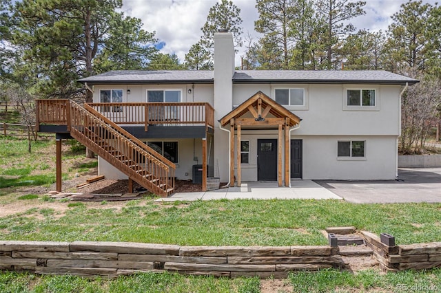 721 Forest View Rd, Monument, CO 80132 - rear view of property featuring a wooden deck, stairway, a patio, a chimney, and a lawn