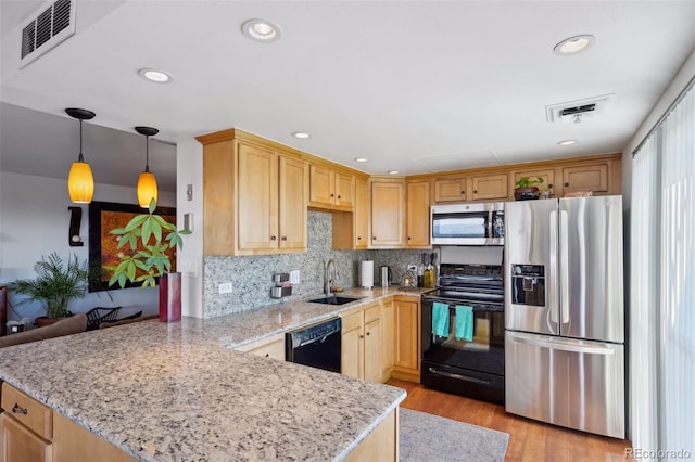 kitchen featuring visible vents, a sink, a peninsula, and black appliances