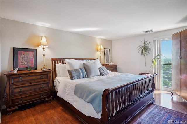 bedroom featuring dark wood-type flooring, visible vents, and access to exterior