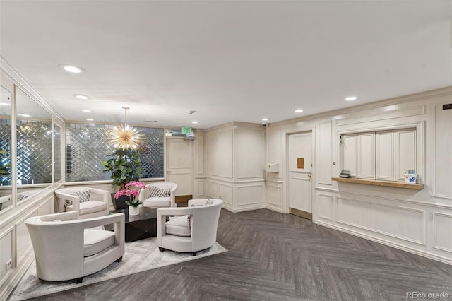 living area with a chandelier, a decorative wall, and recessed lighting