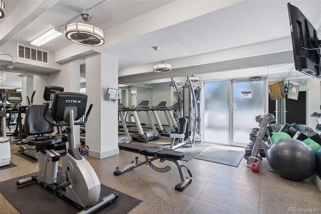 exercise room with baseboards and visible vents