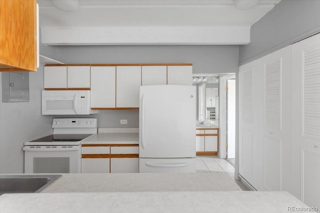 kitchen featuring white appliances, white cabinets, and light countertops