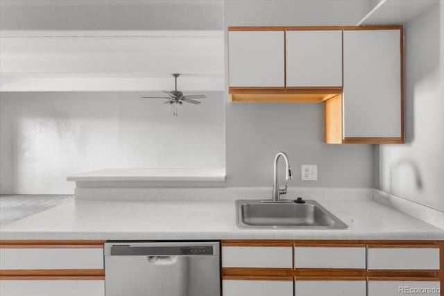 kitchen with light countertops, a sink, dishwasher, and white cabinetry