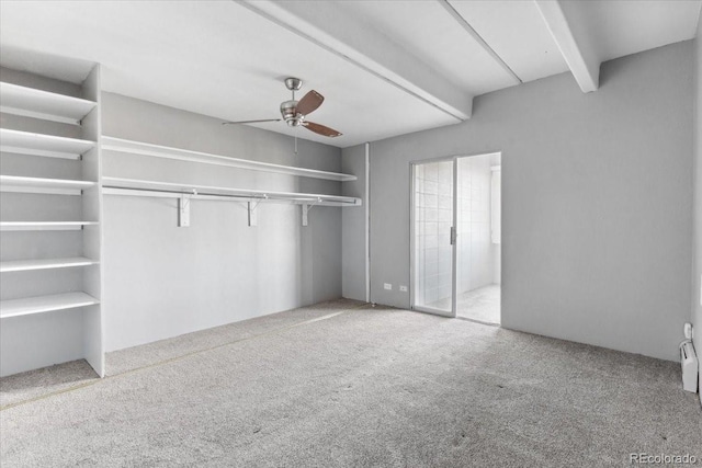 unfurnished bedroom with carpet floors, beam ceiling, and ceiling fan