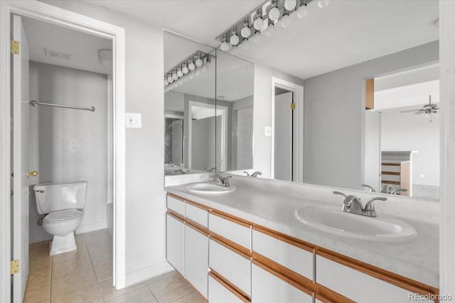 full bath featuring toilet, tile patterned flooring, double vanity, and a sink