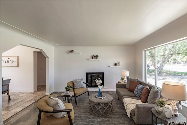 8800 W Kentucky Ave, Lakewood, CO 80226 - living room featuring arched walkways, baseboards, and a glass covered fireplace