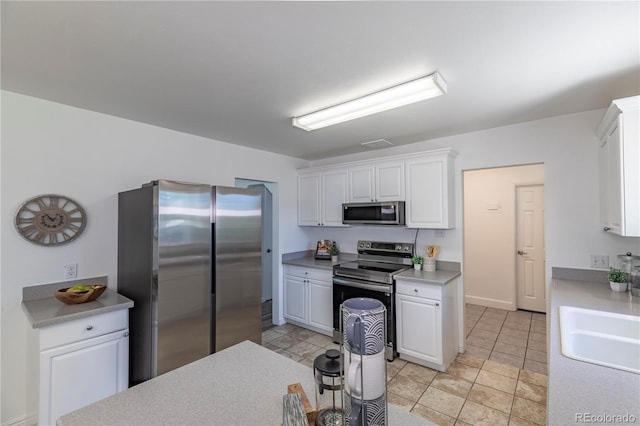 8800 W Kentucky Ave, Lakewood, CO 80226 - kitchen with stainless steel appliances, white cabinetry, light countertops, and a sink