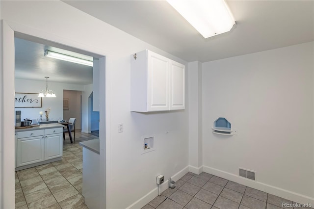 8800 W Kentucky Ave, Lakewood, CO 80226 - washroom featuring washer hookup, a chandelier, cabinet space, baseboards, and light tile patterned flooring