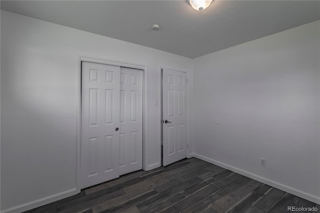 8800 W Kentucky Ave, Lakewood, CO 80226 - unfurnished bedroom featuring dark wood-type flooring, a closet, and baseboards