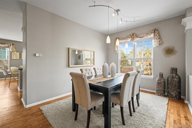 dining space with light wood-style floors and baseboards