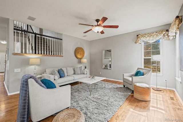 living room with visible vents, baseboards, ceiling fan, and wood finished floors