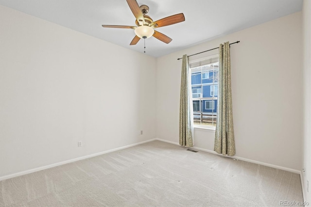 unfurnished room with visible vents, a ceiling fan, baseboards, and light carpet