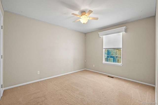 spare room with visible vents, baseboards, carpet, and ceiling fan