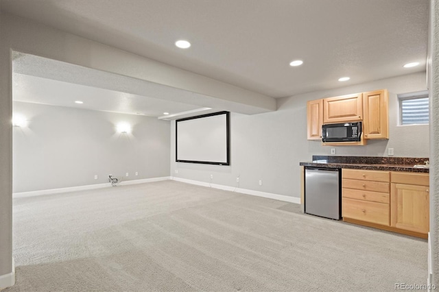 kitchen featuring dark countertops, light brown cabinetry, black microwave, fridge, and light colored carpet