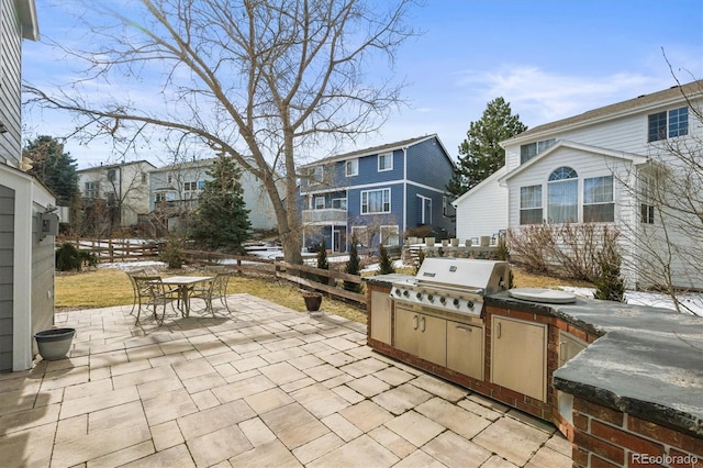 view of patio with fence, area for grilling, outdoor dining area, a residential view, and a grill