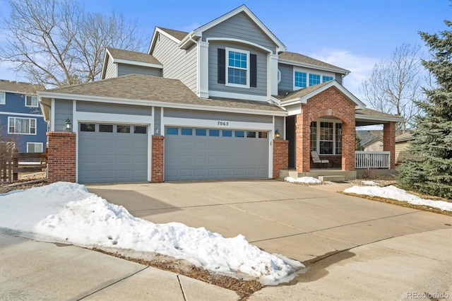 craftsman house with roof with shingles, an attached garage, covered porch, concrete driveway, and brick siding