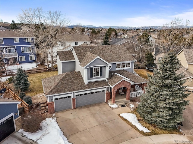 view of front of property with brick siding, fence, a residential view, concrete driveway, and a garage