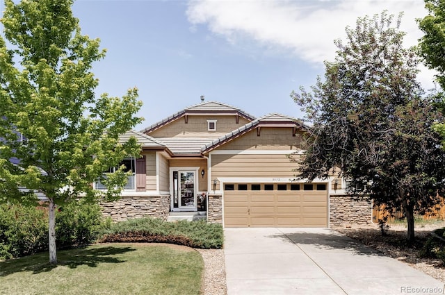 3972 S Shawnee Way, Aurora, CO 80018 - view of front facade with stone siding, concrete driveway, a garage, and a front lawn
