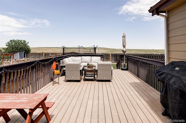 3972 S Shawnee Way, Aurora, CO 80018 - wooden deck with an outdoor living space, a trampoline, and a grill