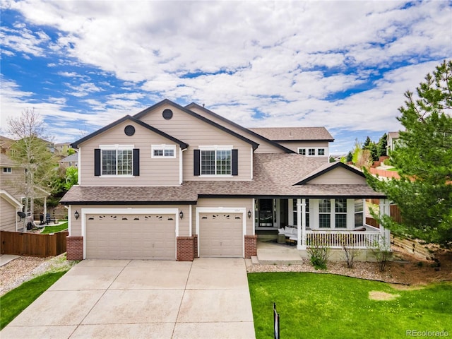 view of front of home featuring a porch, a garage, and a front yard