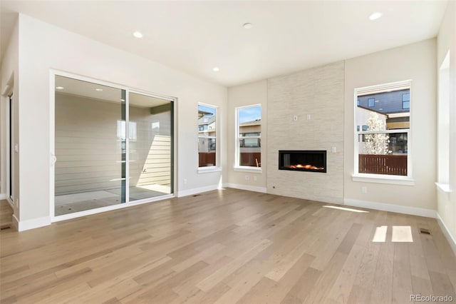 1711 Branching Canopy Dr, Windsor, CO 80550 - unfurnished living room featuring wood finished floors, a fireplace, baseboards, and recessed lighting