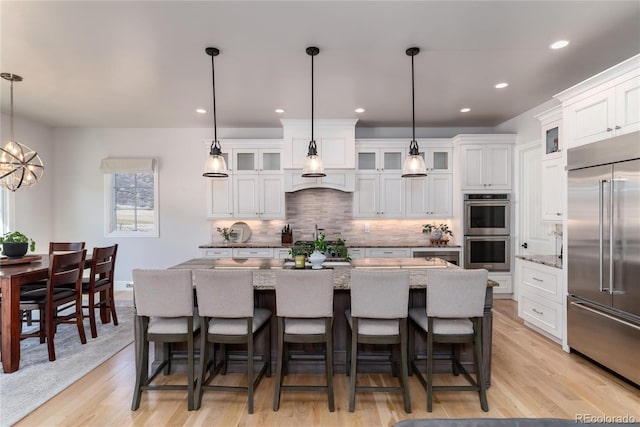 8033 Galileo Way, Littleton, CO 80125 - kitchen with stainless steel appliances, decorative backsplash, light wood-type flooring, white cabinets, and recessed lighting