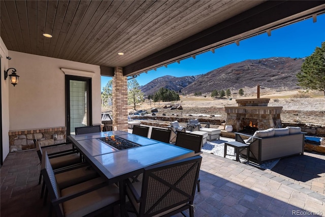 8033 Galileo Way, Littleton, CO 80125 - view of patio / terrace featuring a mountain view, outdoor dining area, and an outdoor living space with a fireplace