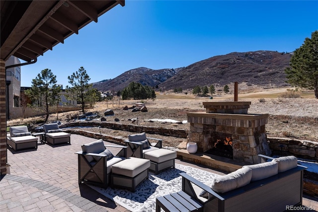 8033 Galileo Way, Littleton, CO 80125 - view of patio / terrace with an outdoor living space with a fireplace and a mountain view