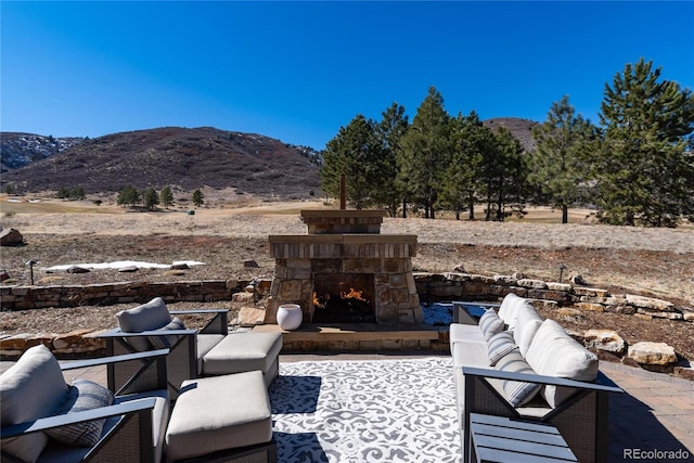 8033 Galileo Way, Littleton, CO 80125 - view of patio / terrace featuring a mountain view and an outdoor living space with a fireplace