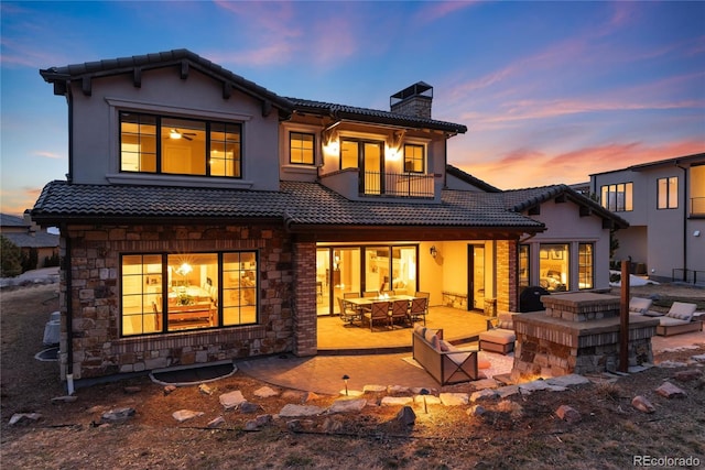 8033 Galileo Way, Littleton, CO 80125 - rear view of house featuring a tiled roof, a chimney, a balcony, a patio area, and an outdoor living space with a fireplace